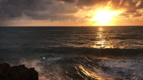 Vista dalla riva di grandi onde marittime che si infrangono contro le rocce in un tempo di tramonto — Video Stock