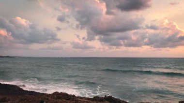 Büyük deniz dalgalarının kıyılarından bulutlu bir günde kayalara çarpan görüntüler.