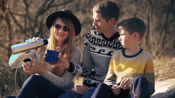 Szczęśliwa rodzina dobrze się bawiąca pijąc herbatę z termosu na świeżym powietrzu — Wideo stockowe
