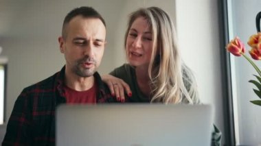 Neşeli bir çift laptopta arkadaşları ya da ailesiyle görüntülü görüşme yapıyor.