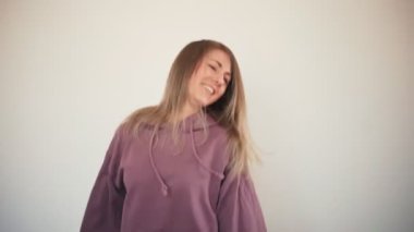 Uzun saçlı komik sarışın kadın zıplıyor ve dans ediyor.