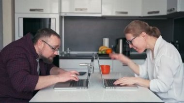 Genç bir çift dizüstü bilgisayarlarında yazı yazıyor..