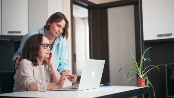 Mujer joven sonriente enseñando a sus padres a usar una computadora. — Vídeos de Stock