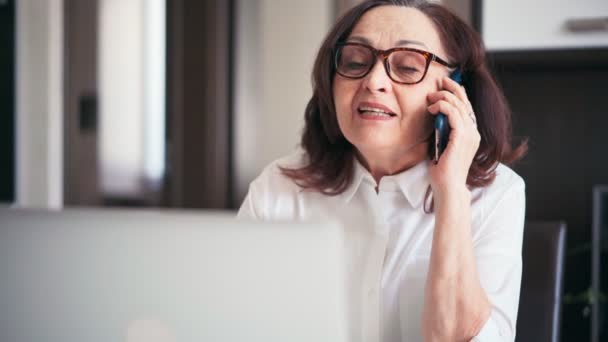 Starsza kobieta psycholog konsultacji pacjenta przez telefon — Wideo stockowe