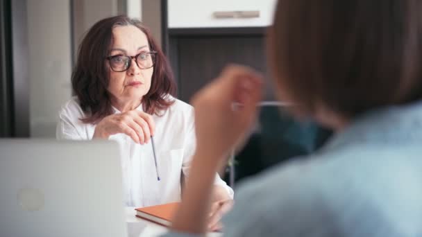 Medelålders gammal affärskvinna manager mentor talar med en kund — Stockvideo