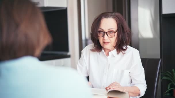 Seorang psikolog wanita dewasa yang perhatian berkonsultasi dengan pasien di kantornya — Stok Video