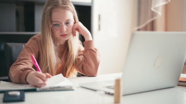 Beautiful 10 years old girl doing her homework using a laptop — Stock Video