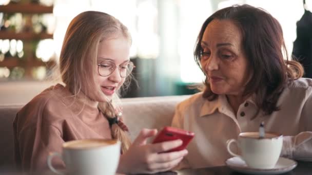 Glad mormor och söt sondotter som använder mobiltelefon tillsammans — Stockvideo