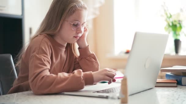 Όμορφη κοπέλα 10 ετών κάνει την εργασία της χρησιμοποιώντας ένα φορητό υπολογιστή — Αρχείο Βίντεο