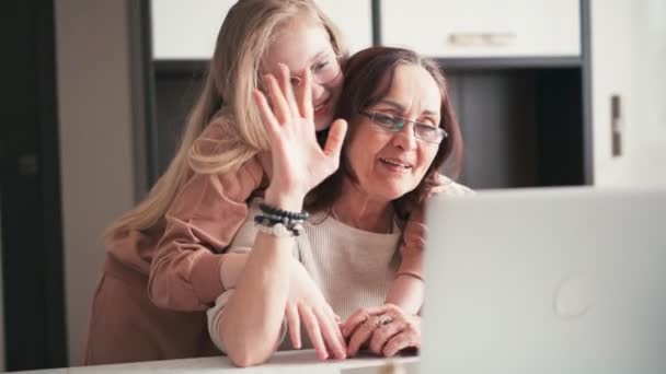 Großmutter mit ihrer 10-jährigen Enkelin bei einem Videoanruf auf einem Laptop — Stockvideo