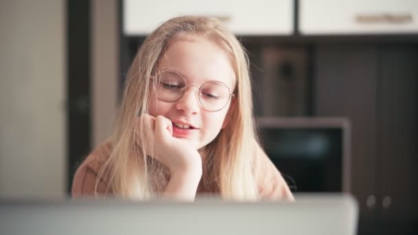 Beautiful 10 years old girl in glasses having a video chat with her teacher — Stock Video