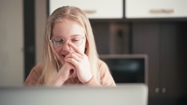 Bella ragazza di 10 anni con gli occhiali che fa una video chat con il suo insegnante — Video Stock