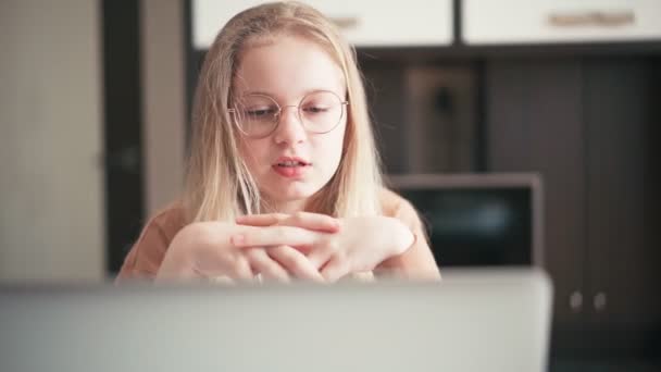 Beautiful 10 years old girl in glasses having a video chat with her teacher — Stock Video