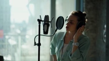 Spiker bir kayıt stüdyosunda bir reklam metni kaydediyor..