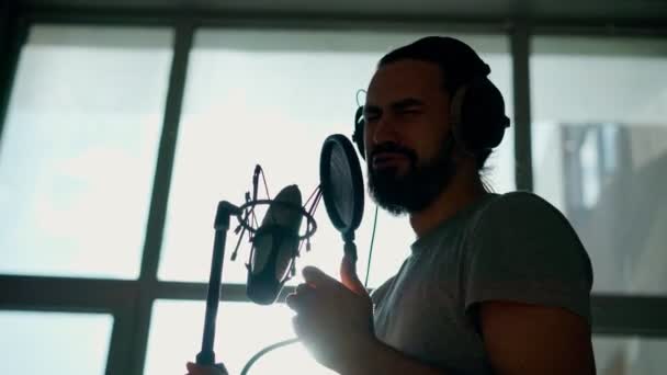 Мужчина-певец записывает песню в студии звукозаписи. — стоковое видео
