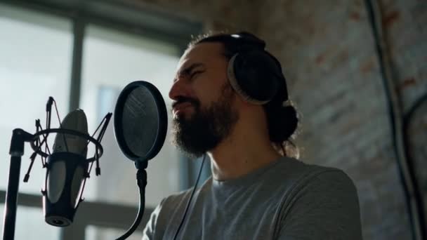 Мужчина-певец записывает песню в студии звукозаписи. — стоковое видео