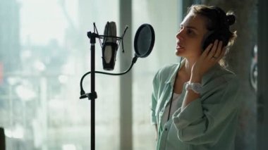 Spiker bir kayıt stüdyosunda bir reklam metni kaydediyor..