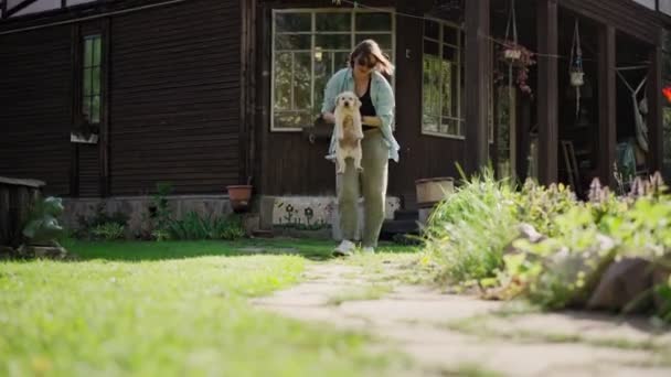 Młoda dorosła kobieta bawi się swoim małym ślicznym szczeniaczkiem labrador — Wideo stockowe