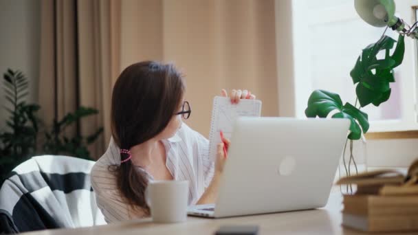 Young woman school teacher working remotely from home using her laptop — Stock Video