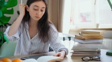 Sınavlara hazırlanan genç bir öğrenci bir kitaptan tablete bir dersi yeniden yazıyor.