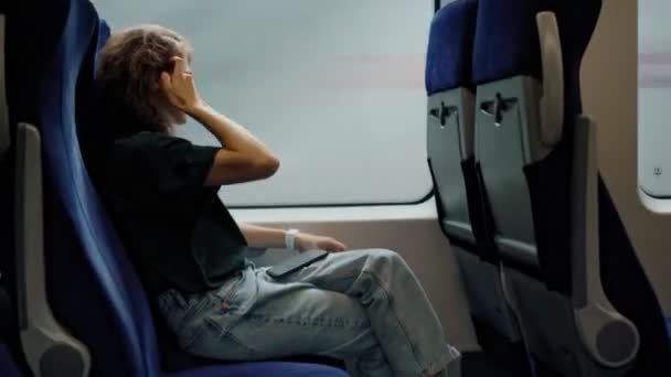 Una mujer joven mirando por la ventana mientras monta en el tren. — Vídeos de Stock