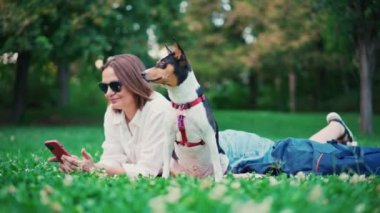 Genç, yetişkin bir kadın sevimli Basenji köpeğiyle selfie çekiyor.