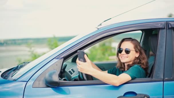 Une jeune femme prend un appel vidéo ou enregistre une vidéo pour son vlog avec un téléphone — Video