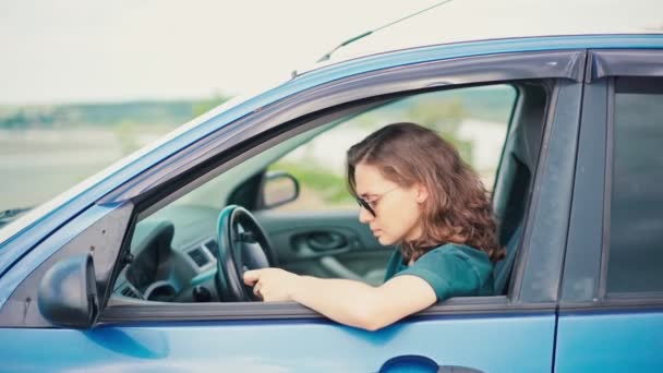 En ung kvinna använder sin telefon och njuter av utsikten medan hon sitter i bilen — Stockvideo