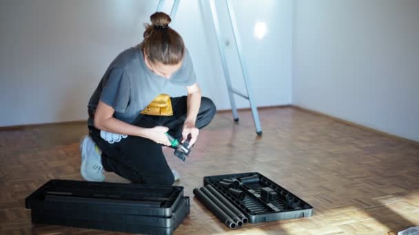 Reparadora profesional con cinturón de herramientas monta un estante de plástico de piezas — Vídeos de Stock