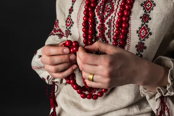 Elinde kırmızı boncuklar. Ukrayna nakış. 