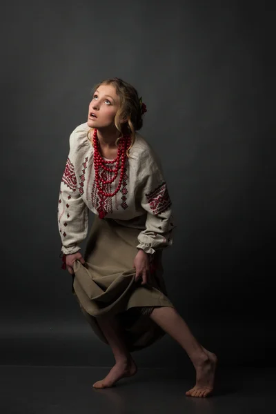 Pretty poor frightened girl  in Ukrainian embroidery caution steps and looking up — Stock Photo, Image