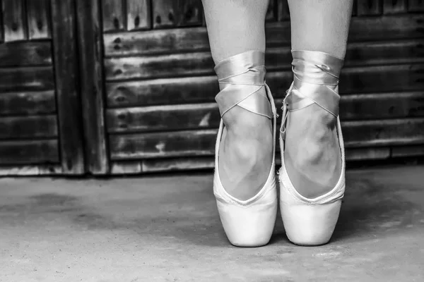 Pés vestidos com sapatos de pontas de dança e sapatos esportivos. Foto em preto e branco — Fotografia de Stock