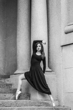 Dansçı pointe ve güzel koyu gri gri bir duvar arka plan üzerinde elbise. Bale, klasik, Modern, çağdaş