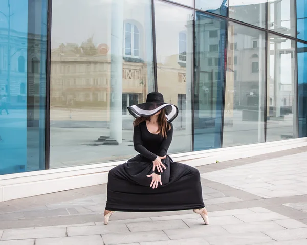 Táncos a kalap és a pointe-ban egy gyönyörű sötét szürke ruha, a háttérben egy ablak. Balett, Modern, klasszikus, kortárs — Stock Fotó