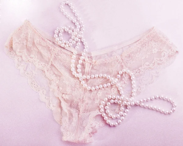 内裤和珍珠在明亮的背景上。微妙的粉红色. — 图库照片