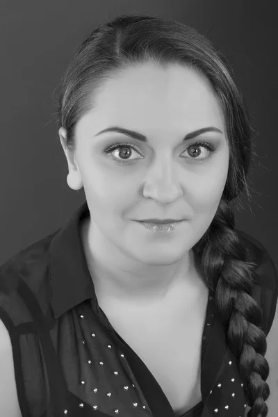 Portrait of a cute woman with a neat day make-up on a gray background. Black and White Photo