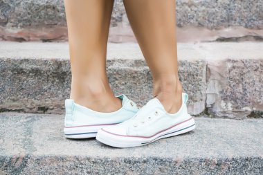 Ayaklar dans pointe ayakkabı, spor ayakkabı taş adımlar arka plan üzerine giymiş. Seksi kadın bacaklar