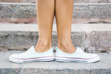 Ayaklar dans pointe ayakkabı, spor ayakkabı taş adımlar arka plan üzerine giymiş. Seksi kadın bacaklar