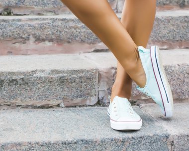 Ayaklar dans pointe ayakkabı, spor ayakkabı taş adımlar arka plan üzerine giymiş. Seksi kadın bacaklar