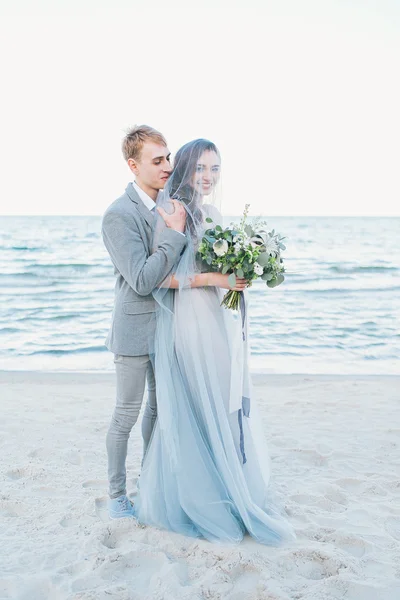 Sposo sposa tenuta in velo in riva al mare — Foto Stock