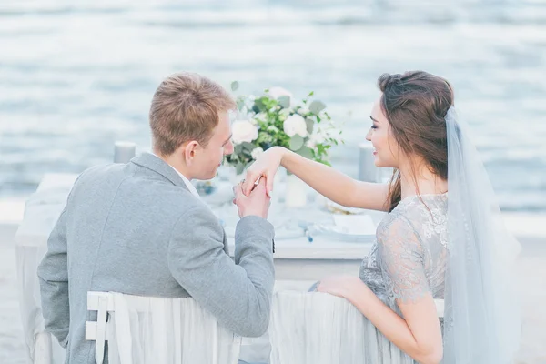 Groom wishing to kiss bride's hand at the seashore — Stock Photo, Image