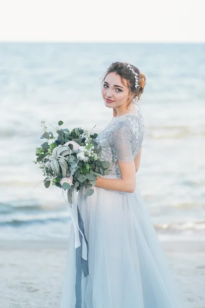 Splendida sposa con bouquet da sposa sul mare — Foto Stock