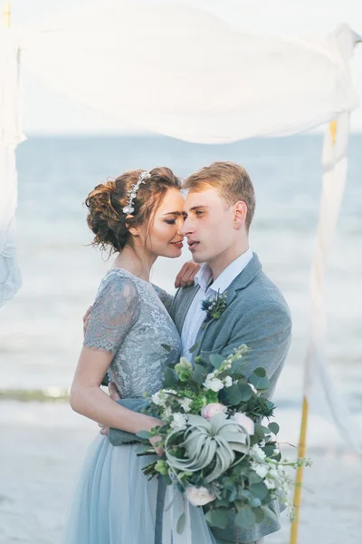Recién casados abrazándose en la orilla del mar —  Fotos de Stock