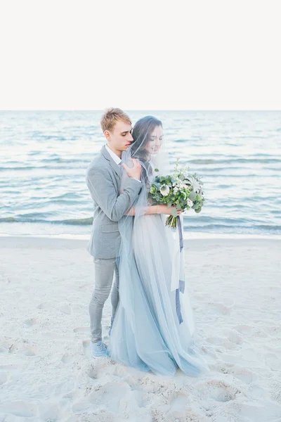 Novio sosteniendo novia en velo junto al mar —  Fotos de Stock