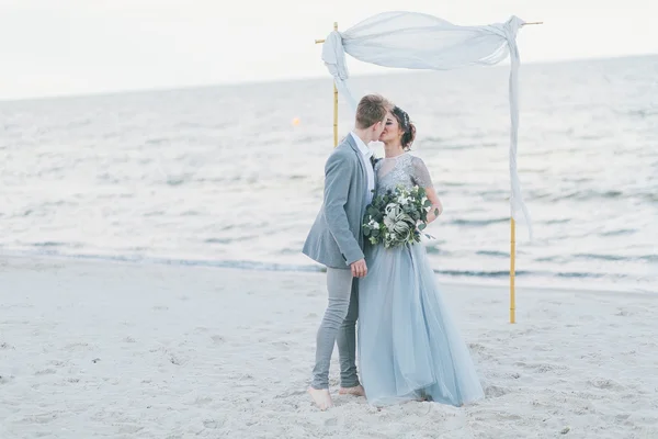 Groom kissing bride at the seashore — Stock Photo, Image