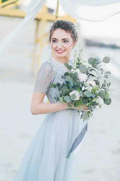 Superbe mariée avec bouquet de mariage au bord de la mer — Photo