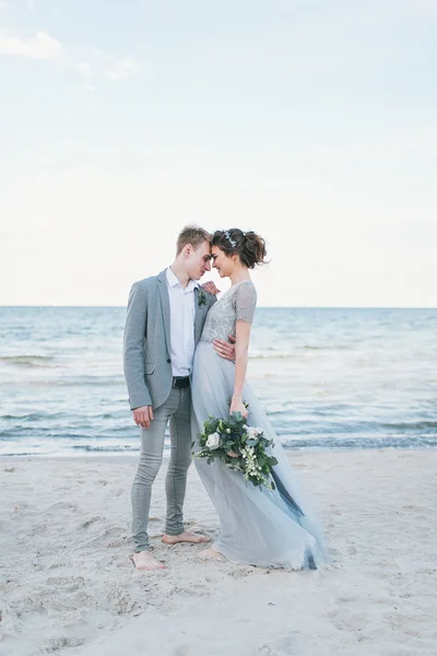 Sposo in braccio sposa al mare — Foto Stock