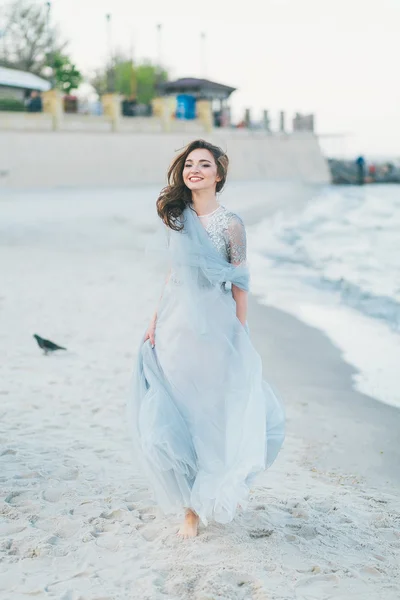 Sposa allegra fare una passeggiata lungo la spiaggia — Foto Stock