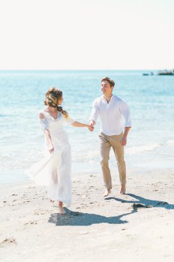 Tutkulu yeni-evliler eğleniyor ve deniz kıyısı çalışan