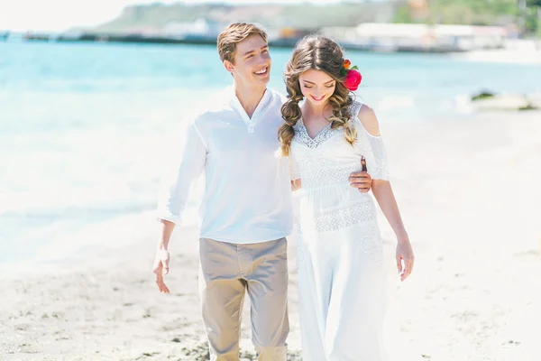 Coppie appena sposate fare una passeggiata lungo la spiaggia — Foto Stock